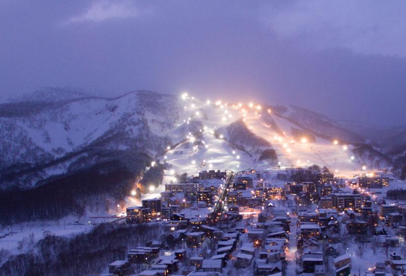 Night skiing in Niseko Hirafu village and resort illuminated for night skiing