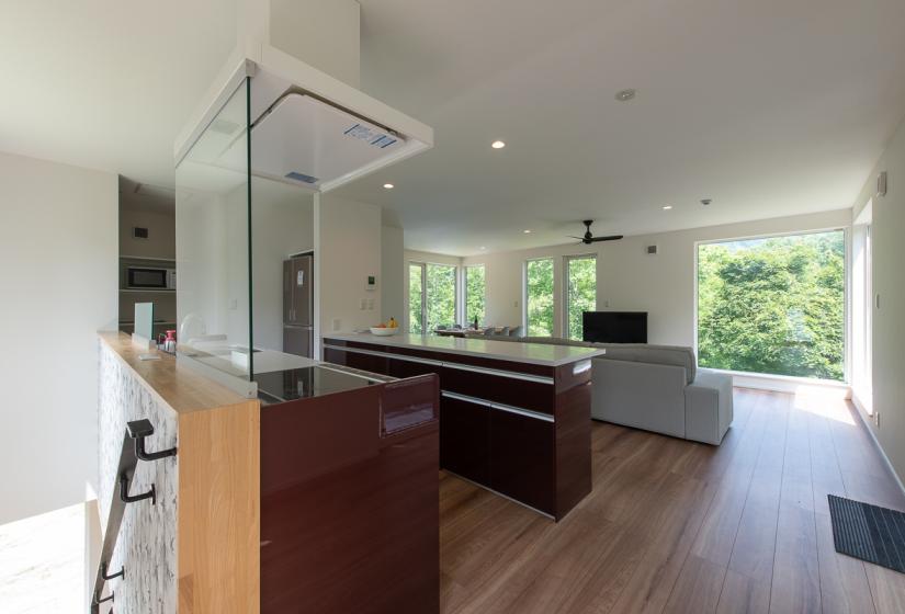A fully equipped kitchen makes meal preparation a breeze. A stove top, kitchen bench and island kitchen and lounge suite behind.