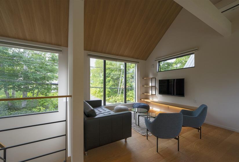 Living area with 2 chairs a sofa and television behind