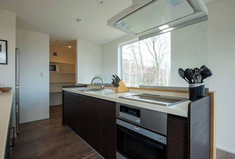 A kitchen bench area with a wooden knife holder and pottery bowls to the left.