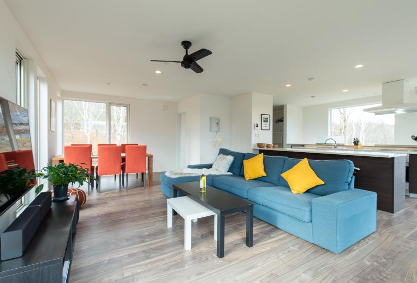 A blue sofa with yellow pillows and coffee table in front.