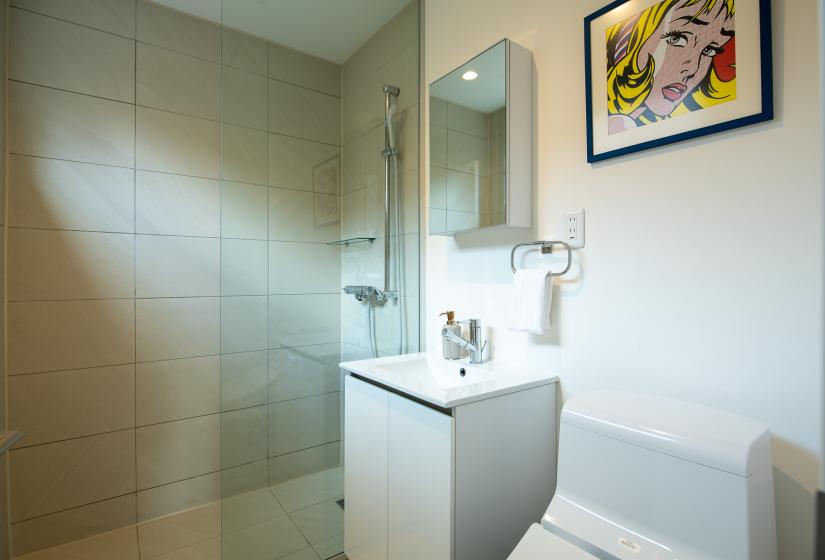 A bathroom with fawn coloured tile, white basin and toilet.