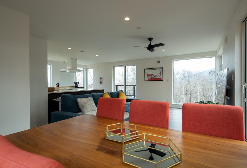 Wooden dining table with small brass baskets and red chairs