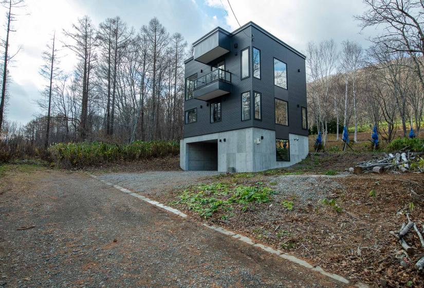 A large 3 story house with grey siding.