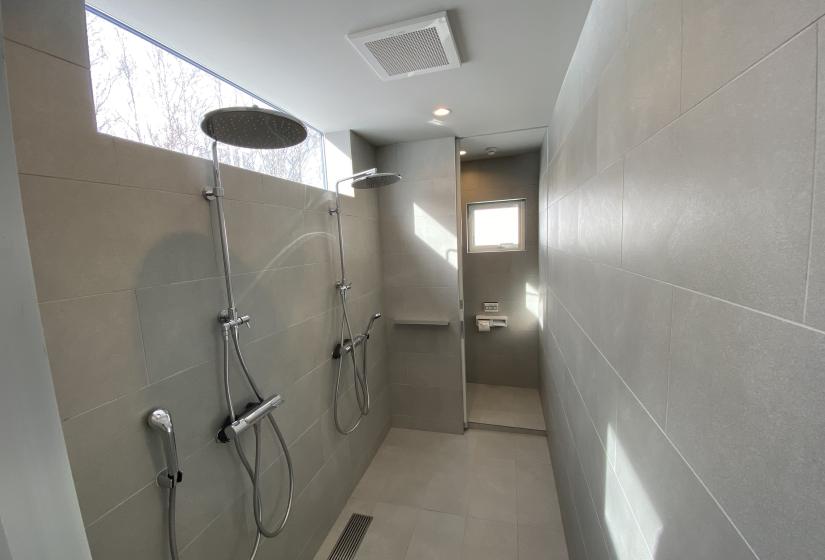 Two rain showers in a grey tiled bathroom