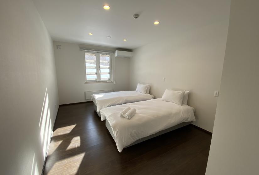 A white bedroom with 2 single beds