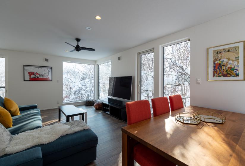 A dining table with blue lounge suite to the left