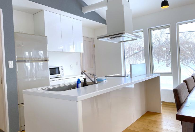 A white kitchen bench with kitchen behind