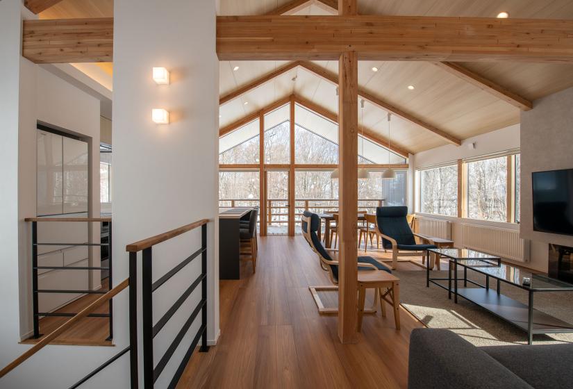 A large living room with exposed beams and wooden floors.