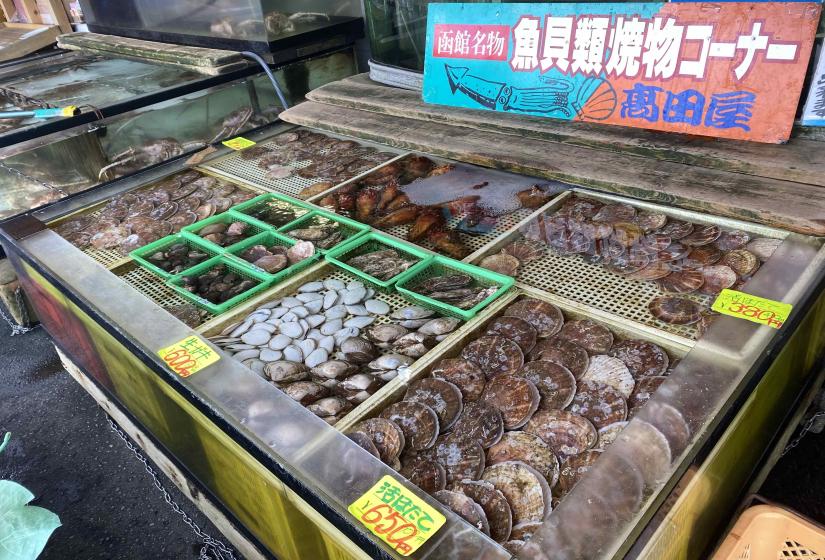 Live shellfish displayed is wooden cases.   
