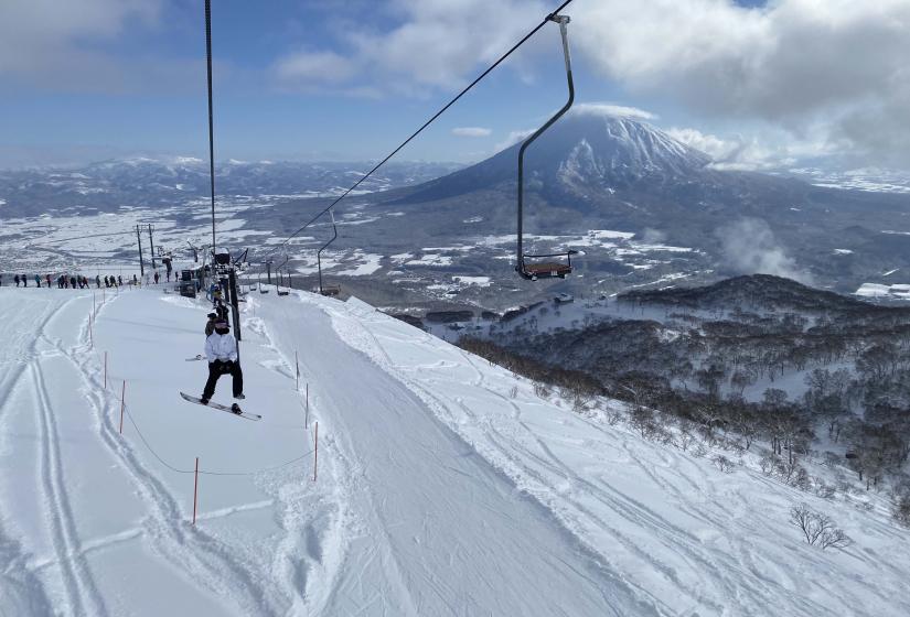 The Hanazono single chair, better known as the pizza box or meat hook is the beginning of your Annupuri Peak adventure. A person sitting on single chair.