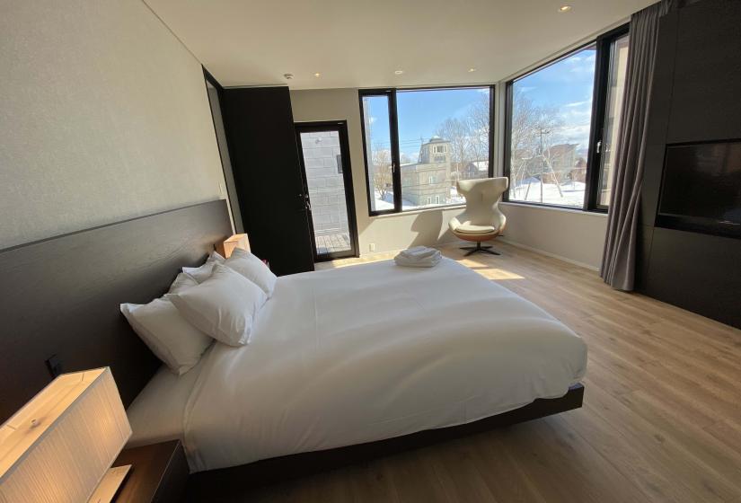 Aozora Master Bedroom A made up double bed with windows behind
