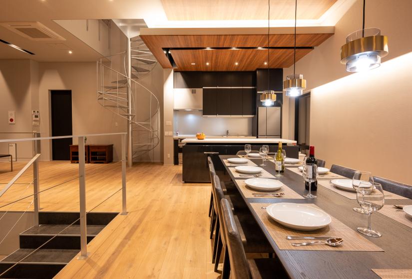 A long dining table with pendant lights above