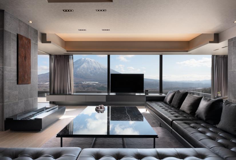 A long black leather lounge suite and expansive window