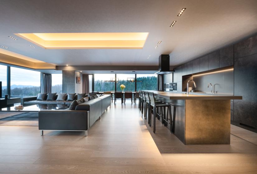 A kitchen island bench and lounge to the left
