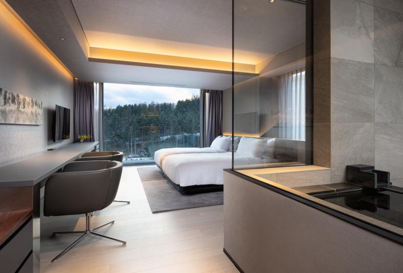 An office desk and two beds behind.