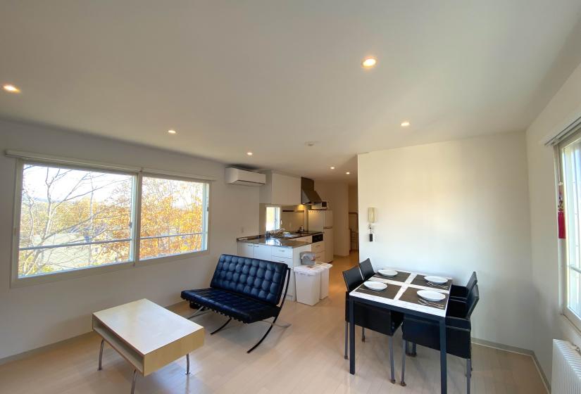 Dining table and couch with kitchen behind