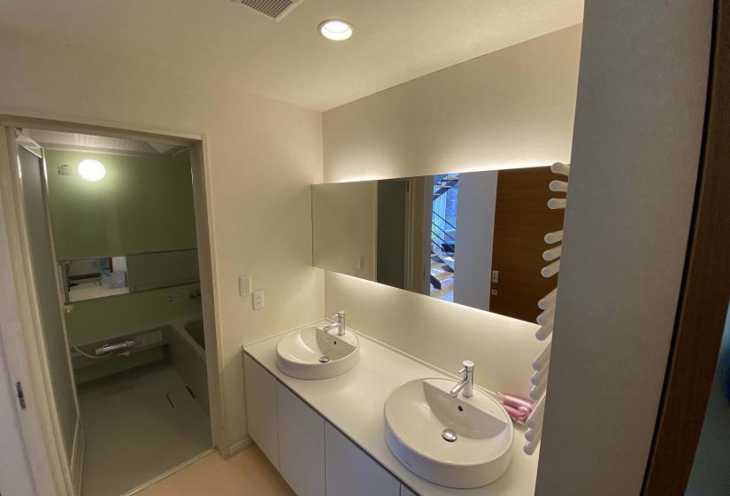 Two twin sinks with mirror above and unit bath behind