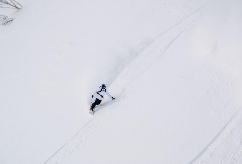 The wide open terrain on offer can make a nice change to more tree oriented riding we often associate with Niseko. Photo Glen Claydon A snowboarder makes a turn in powder snow