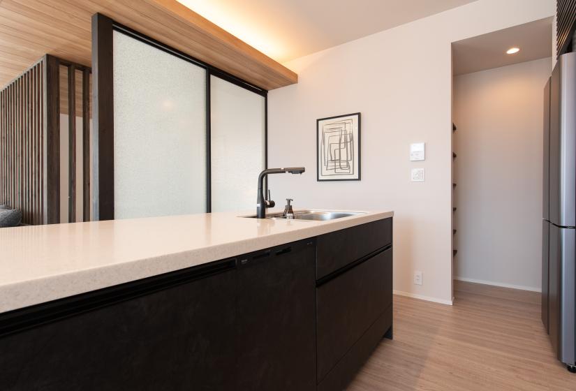 A kitchen bench and framed picture on wall behind.