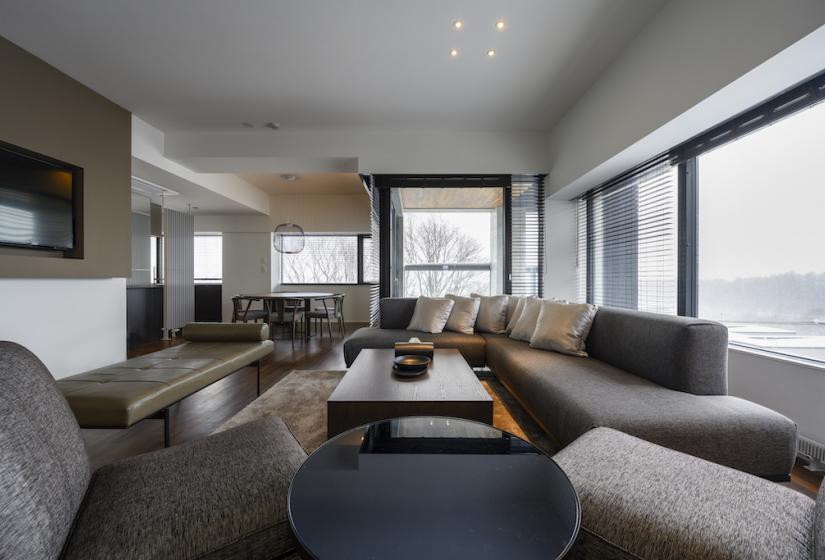 A lounge area with grey  and brown furniture