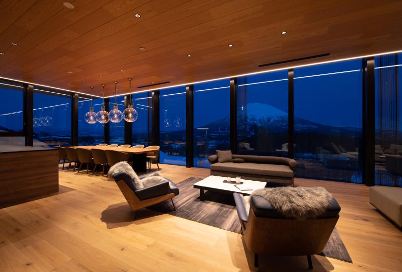 A lounge and dining area with night view of mountain behind