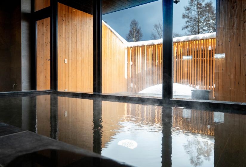 An onsen with a snow capped fence