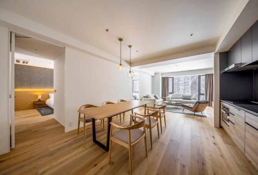 a wooden dining table in large apartment dining area