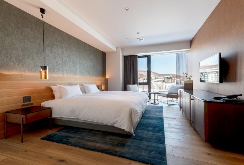 Hotel room with white bedspread and hangiong light