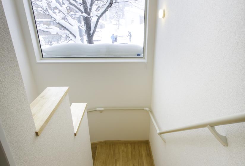 A stairway with view of snowy tree