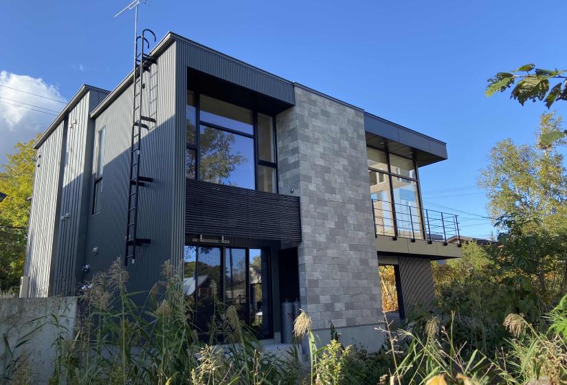 The exterior of a large 2 bedroom home clad in stone and steel