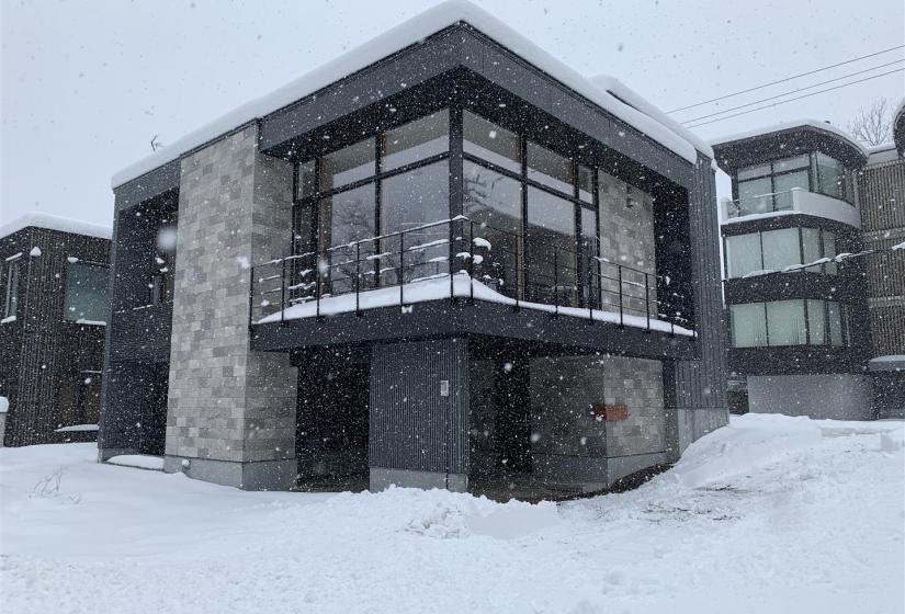 The corner of a two story home in the snow.