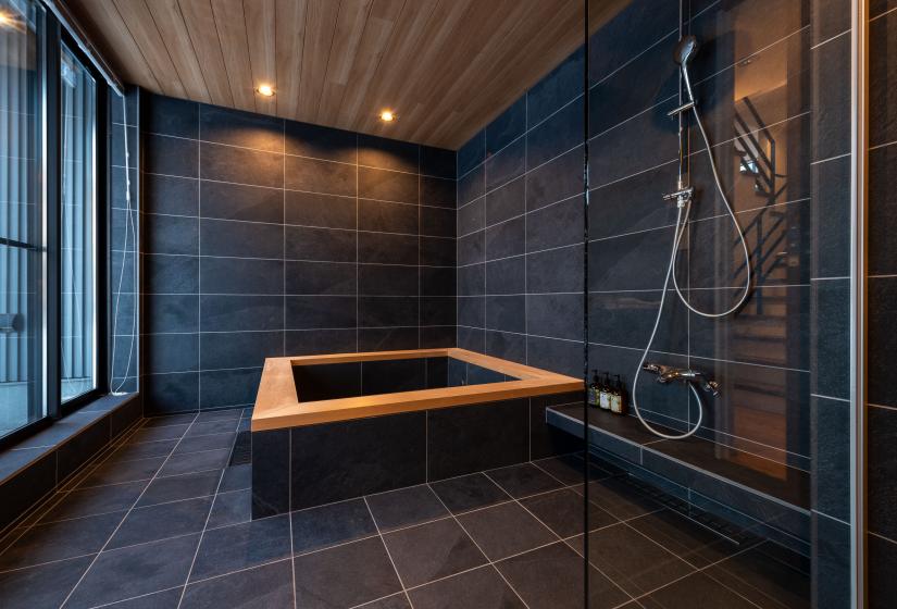 A large bath tub with wooden edge