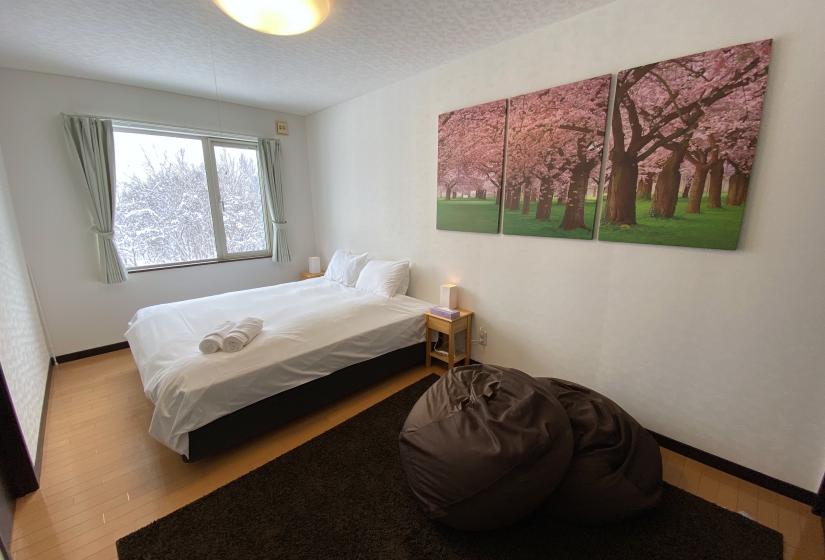 Yotei Chalets bedroom 2 A made up double bed and blossom painting