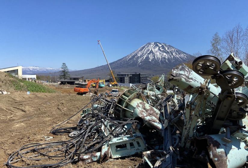 A pile of scrap metal with Mount Yotei in the back ground