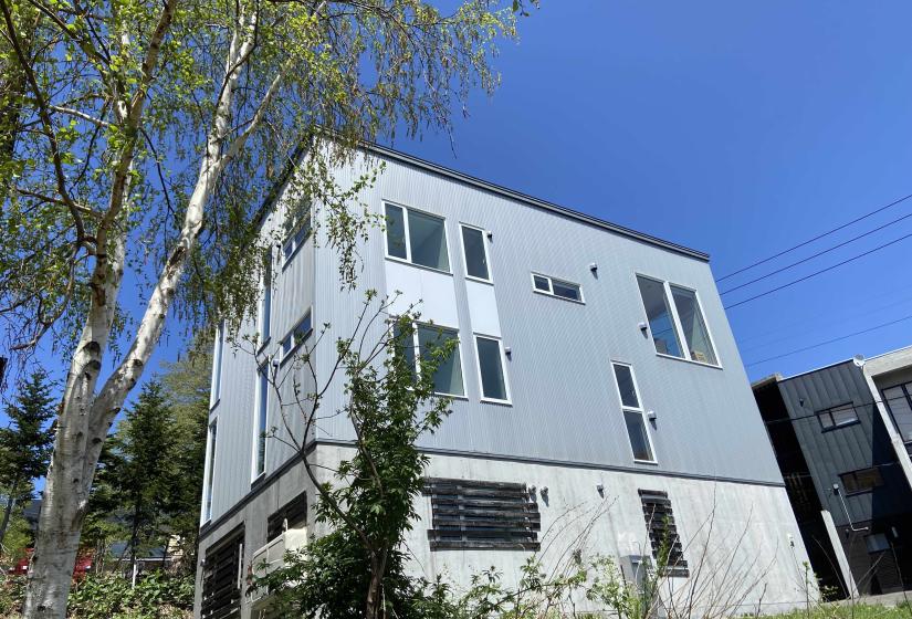 A 3 story house with grey cladding.
