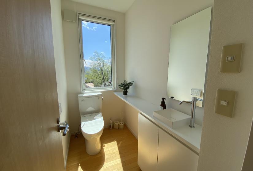 A toilet with window behind