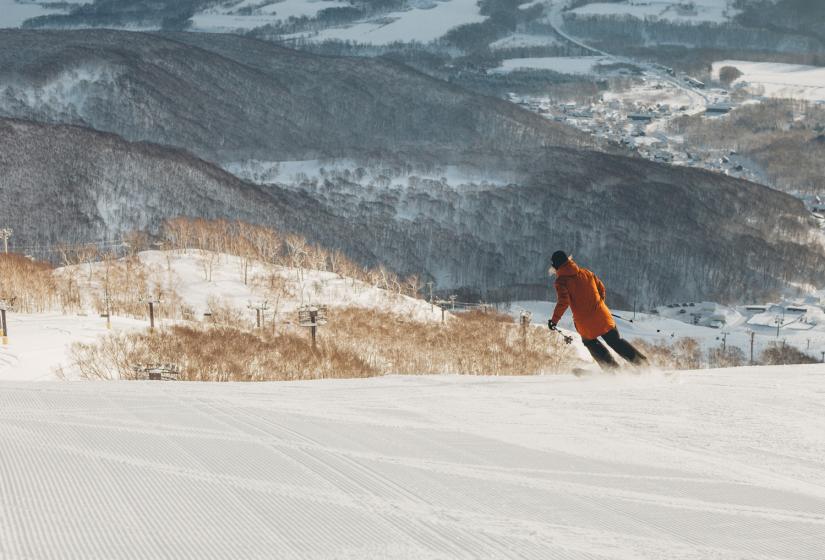 Less crowds, near empty slopes and great times. A lone skier on a slope