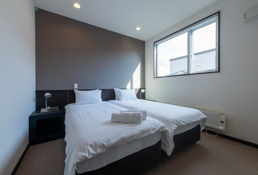 Two single beds below a window