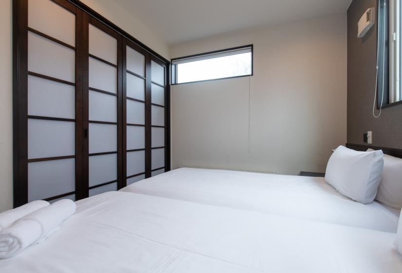 Two single beds with pillows and towels
