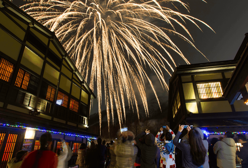 New years fireworks illuminate the traditional style buildings of Niseko Village. Fireworks behind Niseko Village