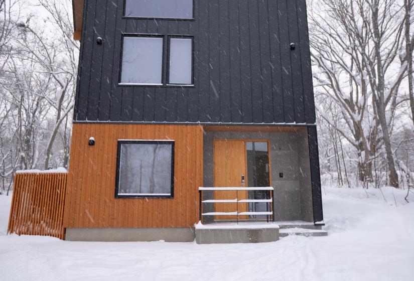 An exterior shot of a two story house with wood and steel cladding