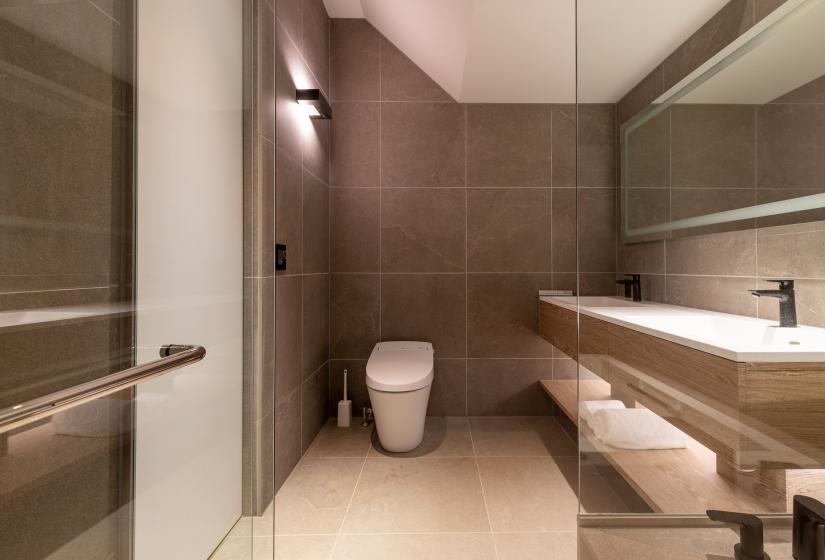 A toilet and bathroom to the right