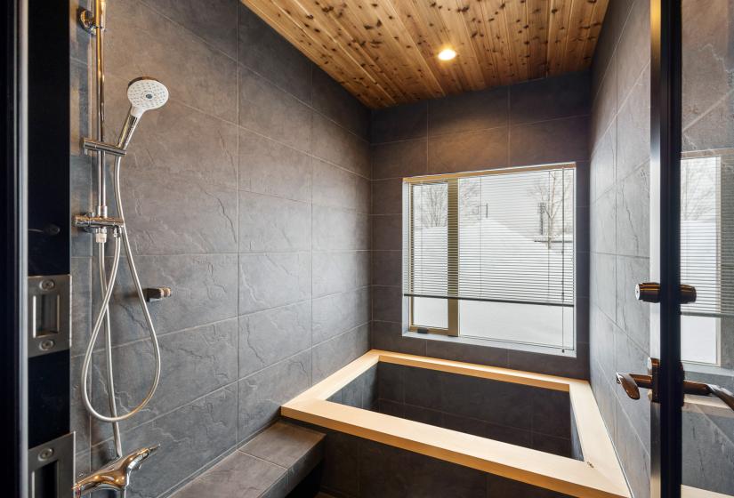 Wooden rimmed bath in tiled bathroom