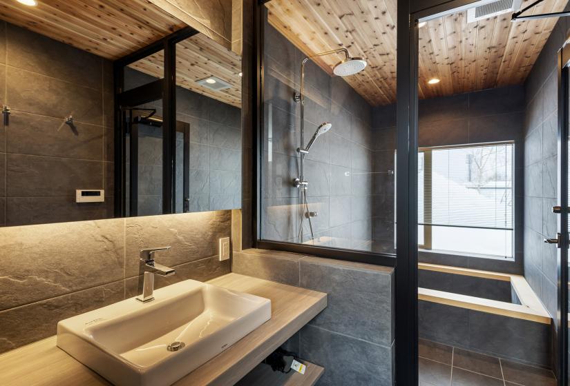 Bathroom sink and wooden edged bath behind