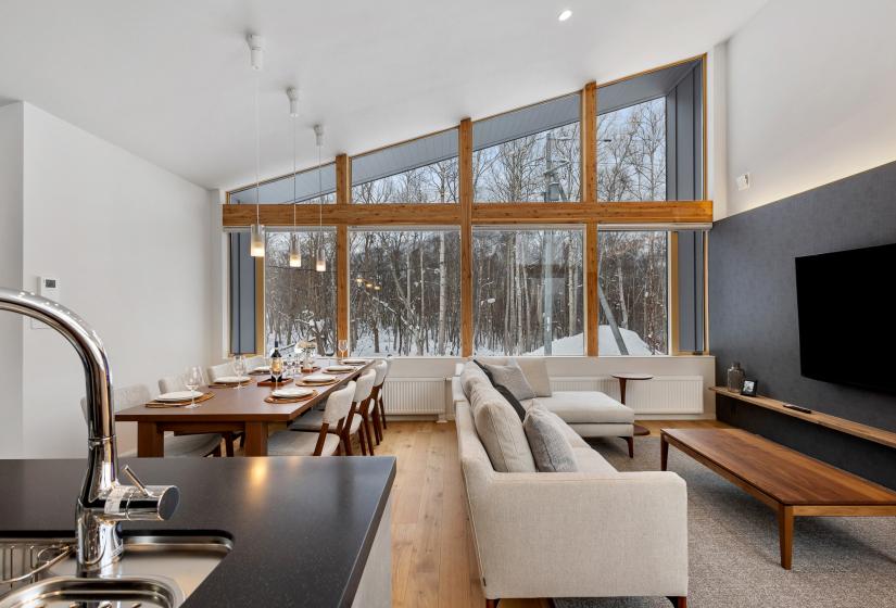 A kitchen bench, lounge and dining table behind