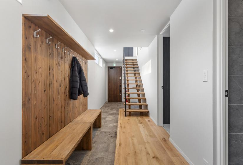 Along bench with coat racks and stairs behind