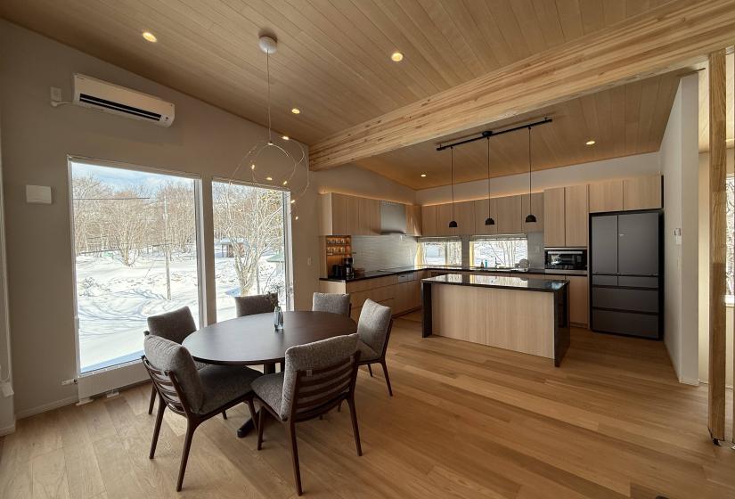 A round dining table and kitchen behind
