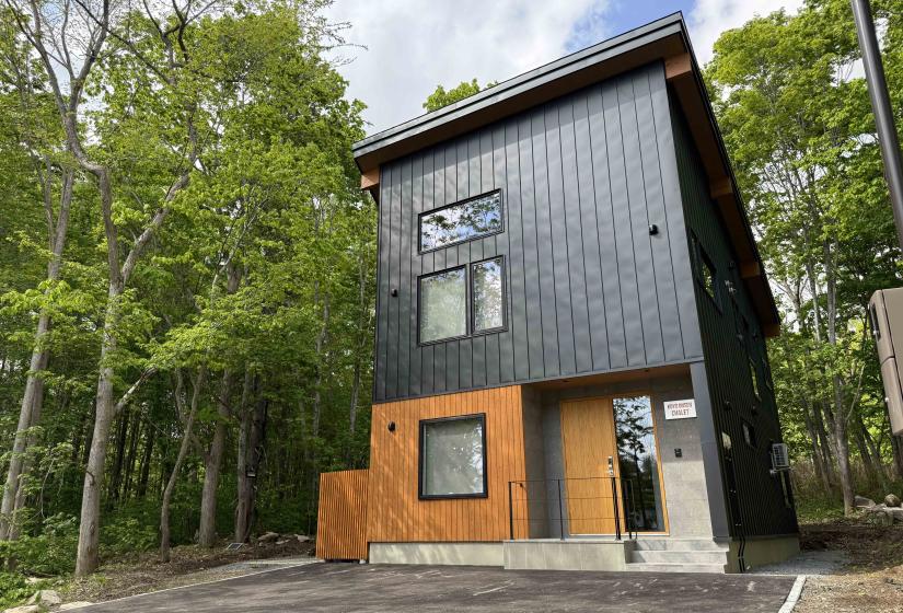 The exterior of a two story house with black siding