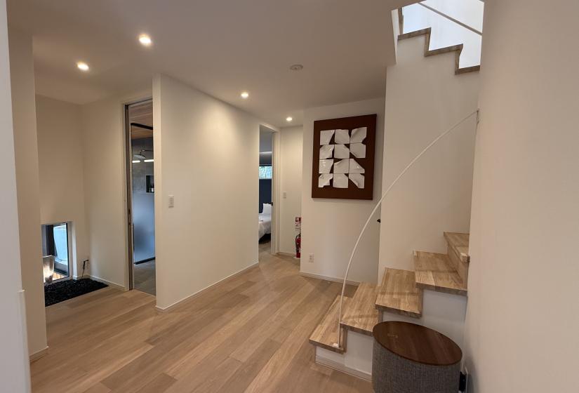 A landing with stairs to the right and an abstract picture on the wall